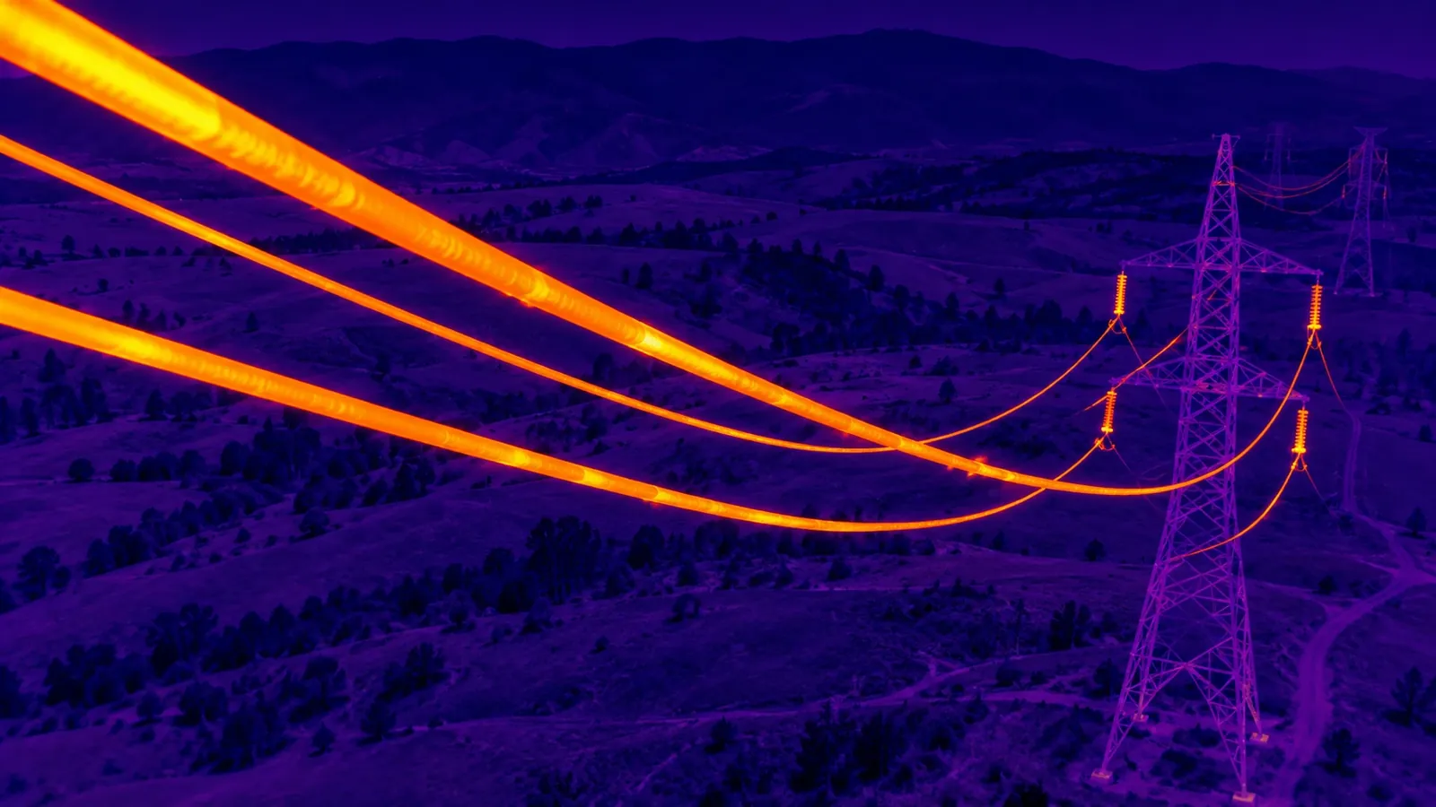 Imagen termográfica aérea de una línea de alta tensión donde los conductores aparecen en naranja sobre un valle en tonos violeta